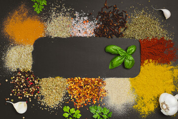 Frame made with different spices on dark background, flat lay. Space for text