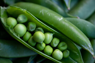 A vibrant macro shot of a freshly opened pea pod, revealing a perfect row of plump, green peas. Symbolizes freshness and wholesome, garden-to-table goodness.
