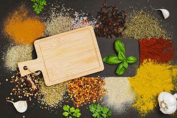 Frame made with different spices on dark background, flat lay. Space for text