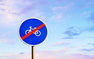 No cyclists road sign on background of the blue sky. The road sign indicates that bicycles and tricycles are prohibited from passing beyond the sign