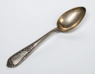 Antique Silver Spoon with Ornate Floral Design on White Background with Subtle Lighting