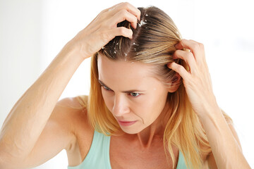 Naklejka premium Woman applying treatment to scalp blonde hair