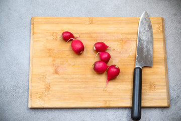 Knife and radish on a wooden board. kitchen