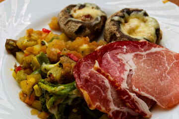 Gourmet Breakfast Plate with Cured Ham and Stuffed Mushrooms on Elegant White Dish
