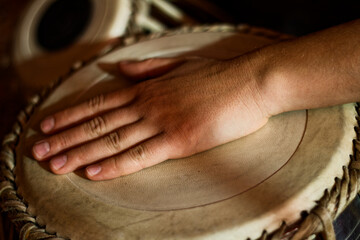 Close-up of Hand Striking Traditional Drum Showing Percussion Technique