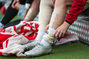 Detail of substitute football player leg on the bench.
