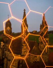 Hexagonal light trails framing old buildings