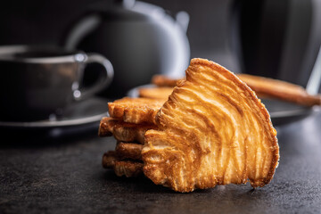 Le sfoglie. Crispy sweet pastry on black table.