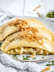 Delicious Homemade Potato Pierogi with Crispy Fried Onions and Green Garnish - A Tasty Vegetarian Comfort Food Dish