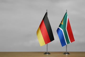 Tabletop flags of Germany and South Africa on stands on a gray blurred background