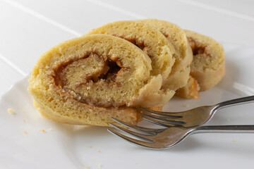 Homemade Swiss Roll Slices on White Plate with Forks