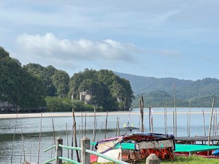 A river with a green forest on either side, big mountain side of river in Krabi Thailand.
