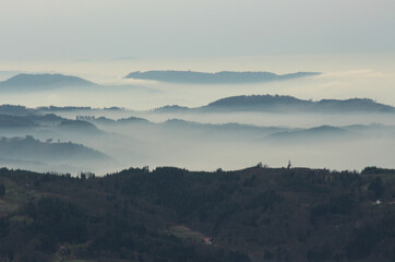 a mysterious landscape of mountains shrouded in fog and towering over the Mummelsee in Germany