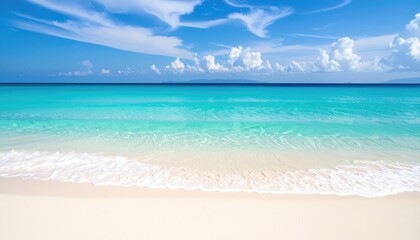 Serene turquoise ocean waves gently lap a pristine white sand beach under a vibrant blue sky.
