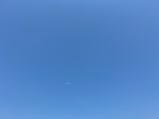 airplane in the blue sky, blue sky with could. Jet airplane flying overhead in clear blue sky diagonally with condensation trail, Aircraft in the air.
