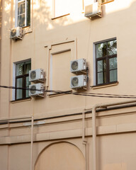 group of air conditioners is mounted on the wall of the building. cooling in hot weather, technologies for adjusting the temperature in the house. climate and weather conditions.