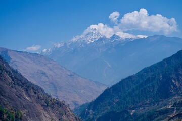 Himalayan mountain landscape in the alps with clouds and blue sky background