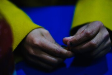 close up women hand wear yellow court on blue background