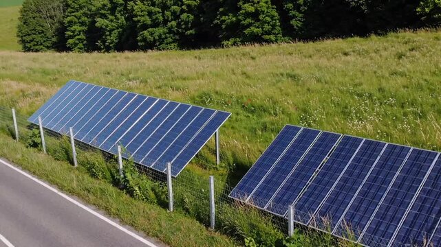 linear arrangement of voltaic modules positioned adjacent to pathway within grassy field