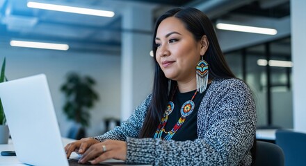 Indigenous Woman Working on Laptop in Modern Office with Traditional Jewelry