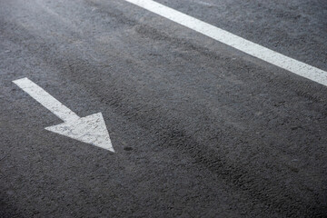 White directional arrows painted on asphalt, symbol of choice, opposite directions, decision-making...