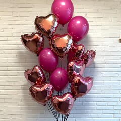 Romantic Pink and Rose Gold Heart Balloons Bouquet Against Brick Wall