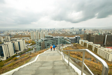 Tourists walking down the stairs overlooking Ulaanbaatar, Mongolia
