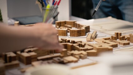 Close up of developers team sharing construction details in a briefing session, analyzing advanced architectural software and 3D models for a modern structural housing project.