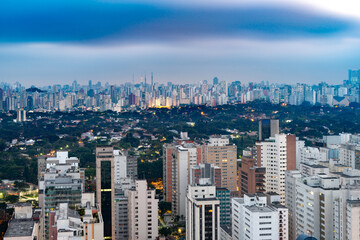 Fototapeta premium Sao Paulo's impressive skyline, with a view of the city's densely populated downtown area and surrounding neighborhoods at dusk.