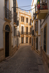 Fototapeta premium Beautiful street in the old town of the city of Ronda at sunset. Malaga, Andalucia, Spain.