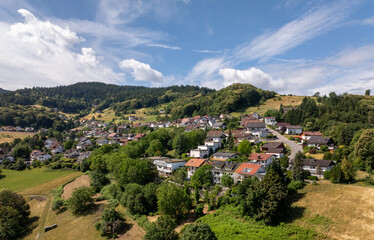 Fototapeta premium Aerial view of Buhlertal, a charming village nestled in the black forest mountains of Germany, showcasing its picturesque houses, lush greenery, and serene atmosphere