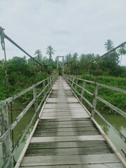 Obraz premium Jembatan, jembatan kayu di atas air sungai, air sungai dengan pohon-pohon,wooden bridge the river