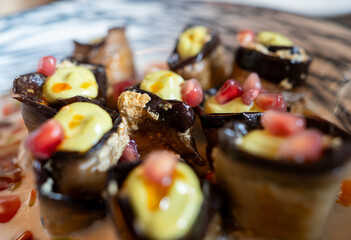 Delicious eggplant rolls stuffed with walnuts, pomegranate seeds and yogurt sauce, creating a visually appealing and flavorful dish