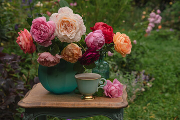 Summer bouquet of english roses with cup of tea