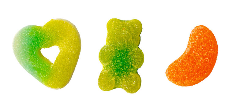 Colorful gummy candy set in bear, heart, and orange slice shapes with sugar and sour coating isolated on transparent for halloween trick or treat concept.