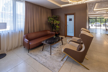 Interior of a hotel lobby with an armchair and sofa, designed for comfort and relaxation