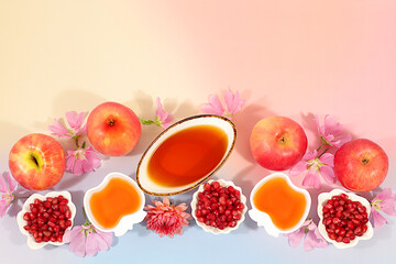 Layout with symbols of the Jewish New Year, template with honey, apples, pomegranate, and flowers. Creative composition for congratulations on the Jewish holiday Ro hashanah, autumn banner