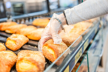 Girl Picking Up Buns At Supermarket In Bakery Section With Close-Up Of Hands
