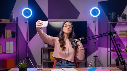 A woman records a video with a ring light and microphone