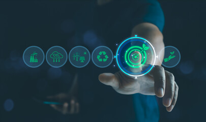 Businessman touching virtual sustainability icon with renewable energy, recycling, and carbon...