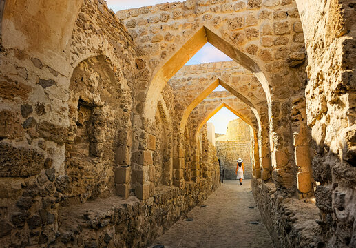 A tourist walks under ancient arches on a narrow path at Qal&rsquo;at al-Bahrain Portuguese Fort, the ancient capital of Dilmun civilization, in Bahrain.