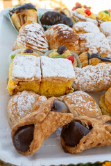 Italian sweet dessert dolce pastry and cakes with cream and fruits on plate made in artisanal bakery in Rome, Italy, close up