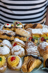 Italian sweet dessert dolce pastry and cakes with cream and fruits on plate made in artisanal bakery in Rome, Italy, close up