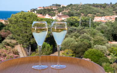 Summer vacation on Mediterranean sea, drinking cold sparkling champagne, cava wine in glass in sunlights, Collioure, Occitanie, South of France, tourists destination