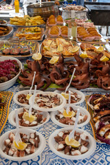 Delicious fresh cooked street food on daily food market in Palermo, Sicily, travel destination, food tourism Italy, variety of raw, roasted, grilled fish, seafood, calamari, sea urchins