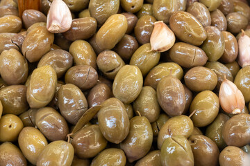 Homemade italian pickled green olives with garlic and spices on food market in Palermo, Sicily, italy