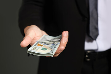 Man with dollar bills on grey background, closeup