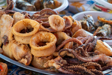Delicious fresh cooked street food on daily food market in Palermo, Sicily, travel destination, food tourism Italy, variety of raw, roasted, grilled fish, seafood, calamari, sea urchins