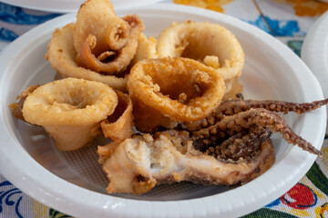 Delicious fresh cooked street food on daily food market in Palermo, Sicily, travel destination, food tourism Italy, variety of raw, roasted, grilled fish, seafood, calamari, sea urchins