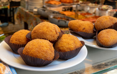 Arancini Sicilian, deep-fried rice balls made with risotto, filled with ingredients mozzarella, ragu, peas, coated in breadcrumbs fried to crispy, brown on market in Palermo, Sicily